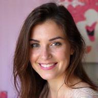 Portrait professionnel souriant de Léa, artiste ongulaire créative spécialisée dans les designs saisonniers et le micro-french, avec un fond doux.